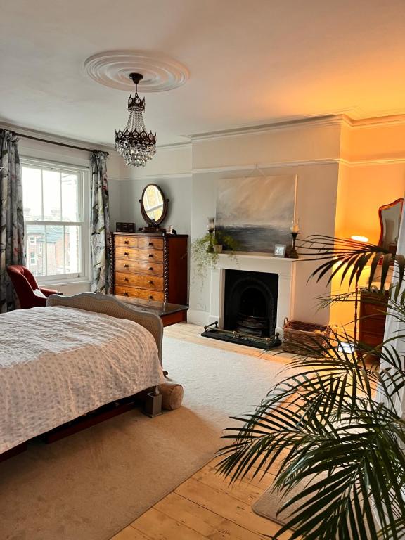 a living room with a bed and a fireplace at Stylish elegant two bedroom apartment overlooking Southsea Common and the Solent in Portsmouth