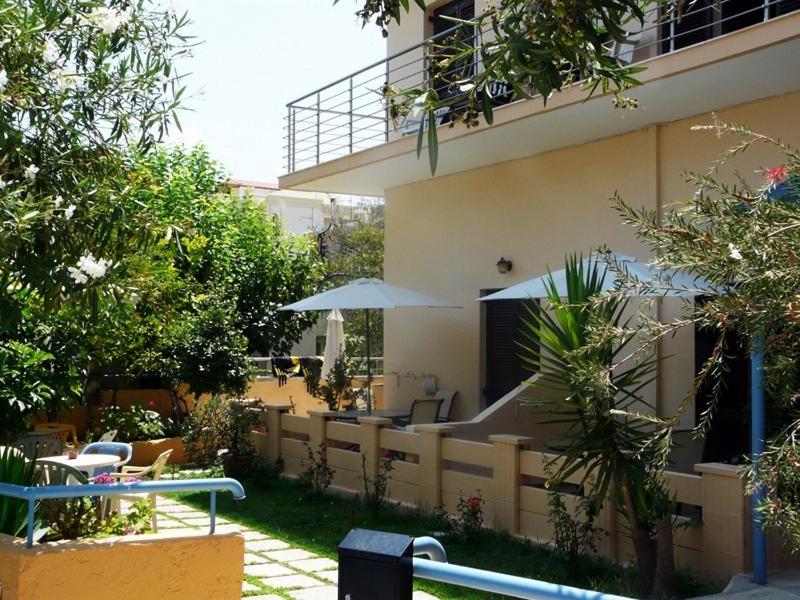 un edificio con un patio con mesas y sombrillas en Alexandros Studios & Apartments, en La Canea