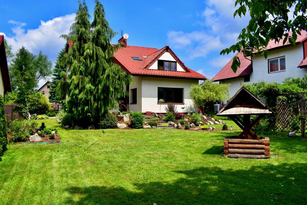 ein Haus mit einem Garten mit grünem Rasen in der Unterkunft Dom wypoczynkowy Milówka in Milówka