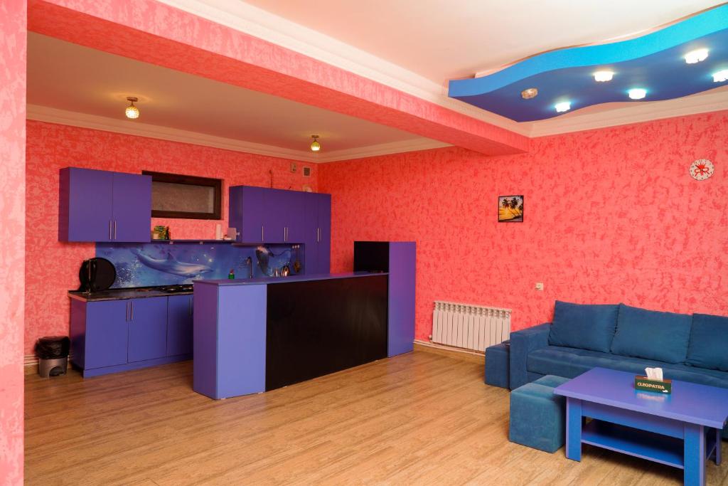 a living room with a blue couch and a kitchen at Royal Rest Townhouse in Dilijan
