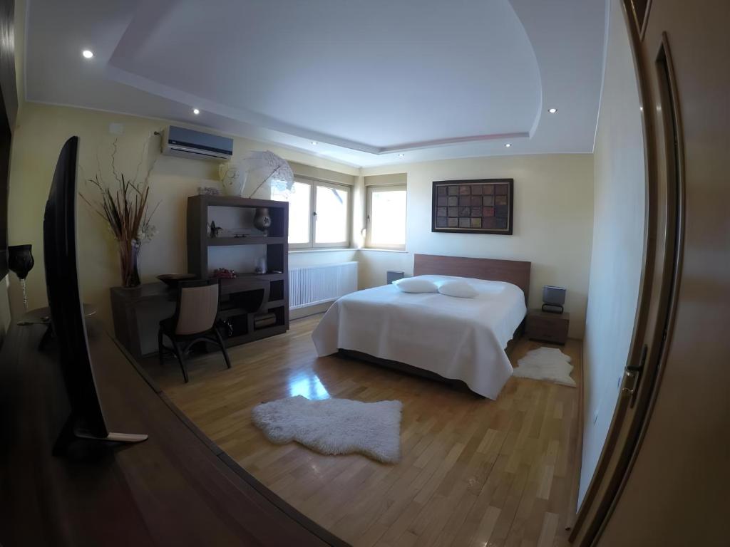 a bedroom with a bed and a desk and a window at Casa Edwin in Constanţa