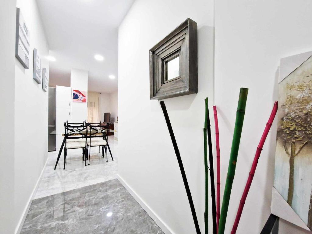 a hallway with white walls and a table and chairs at Alojamientos Fenix in Murcia
