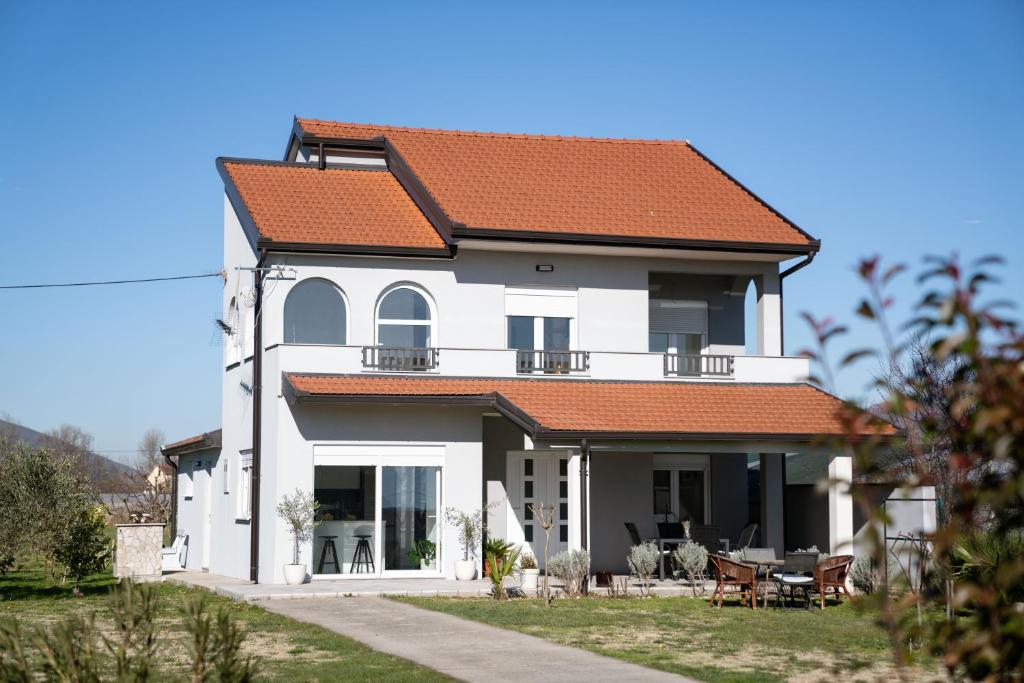 a white house with an orange roof at Lucas apartment in Čapljina