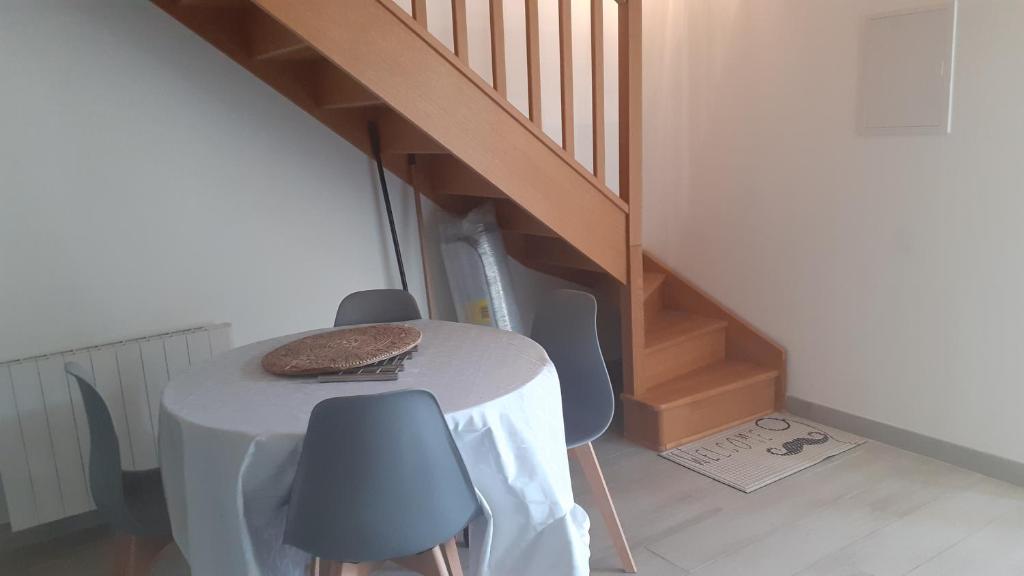 une table et des chaises dans une pièce avec un escalier dans l'établissement Les maisons d'Ustou., à Ustou