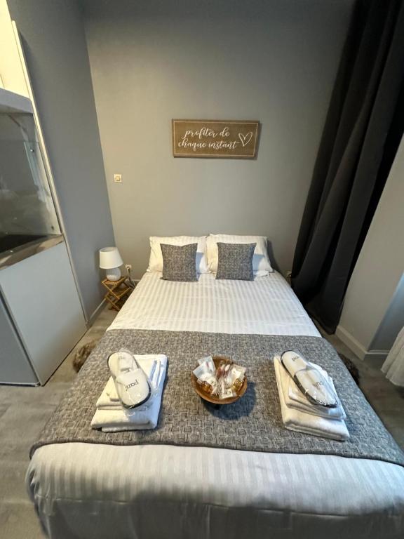 a bedroom with a bed with towels and a tray of food at Location saisonnière Angoulême in Angoulême