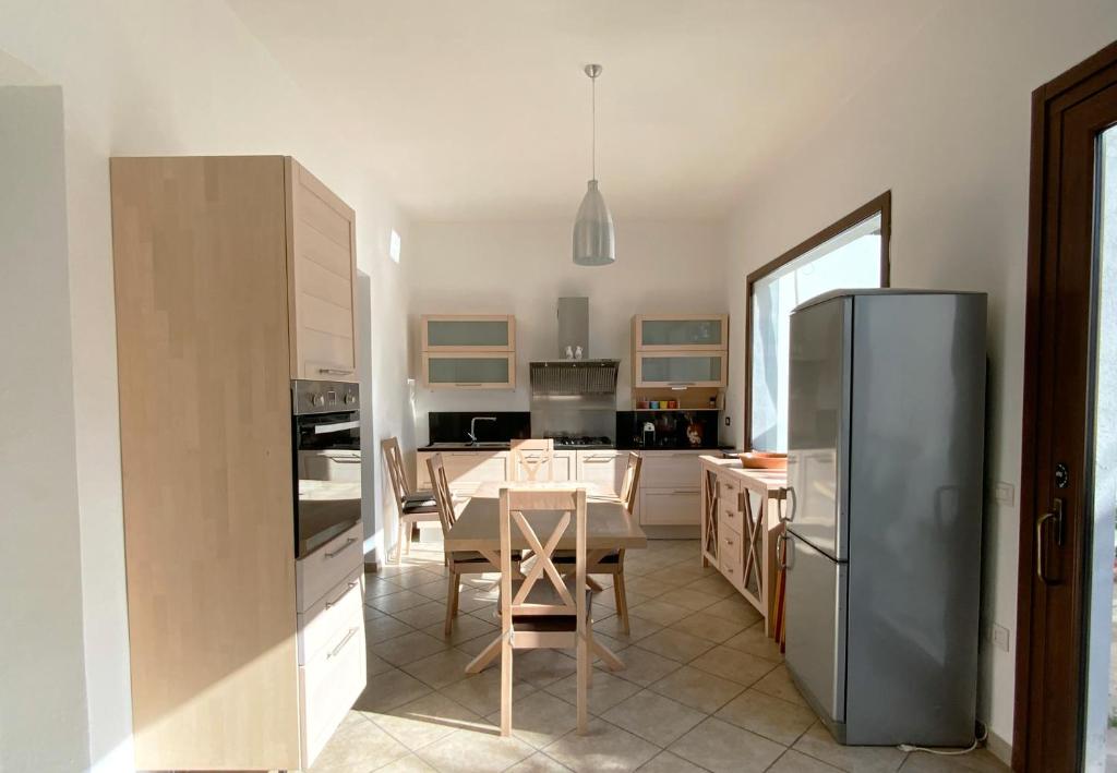a kitchen with a table and a stainless steel refrigerator at Casa Deloy in Elmas