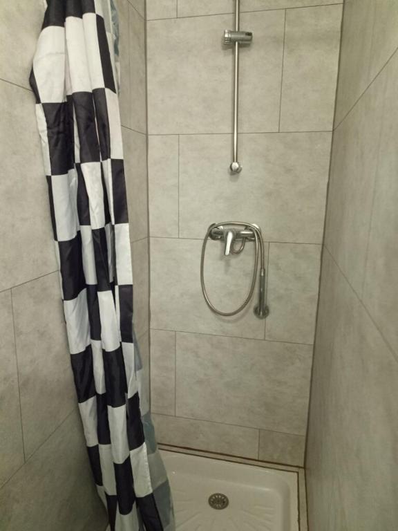 a shower with a black and white curtain in a bathroom at Location saisonnière Angoulême in Angoulême