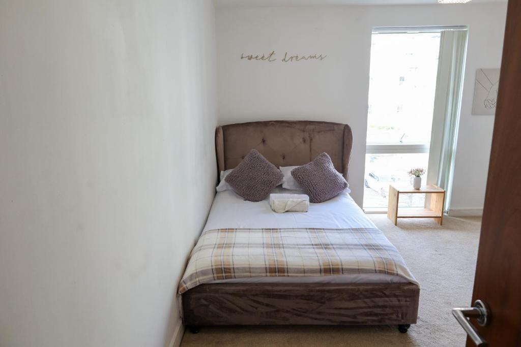 a bed with two pillows and a blanket on it at Centrally located 1BR Apt near Edg Cricket, University of Bham, Priory Hospital & Cannon Hill Park in Birmingham