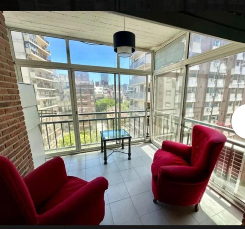 sala de estar con 2 sillas y mesa en el balcón en Lacroze Departamento Buenos Aires en Buenos Aires