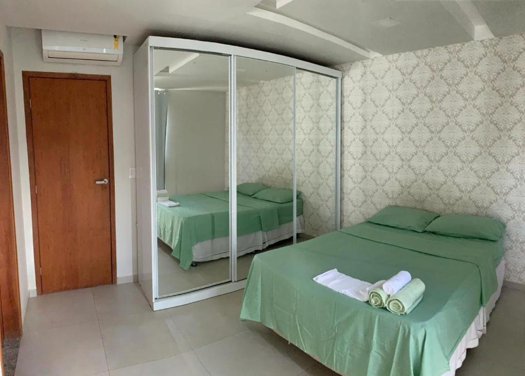 een slaapkamer met 2 bedden en een spiegel bij RB hospedagem in Cabo Frio