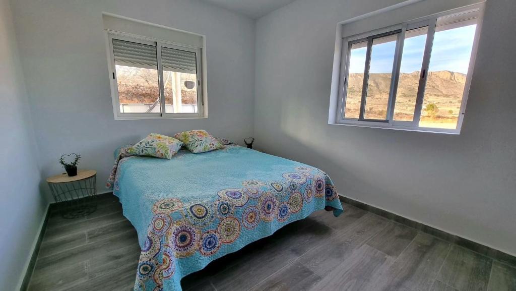 アリカンテにあるCampo tranquilo para desconectarの小さなベッドルーム(ベッド1台、窓2つ付)が備わります。