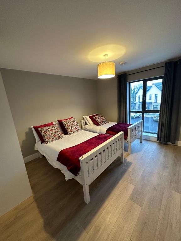 - une chambre avec 2 lits et une grande fenêtre dans l'établissement Home in Kilmuckridge, à Wexford