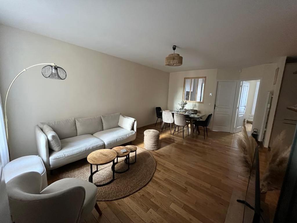 ein Wohnzimmer mit einem Sofa und einem Tisch in der Unterkunft Appartement à 10mn de Paris - PUTEAUX in Puteaux