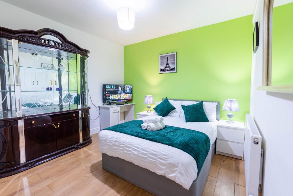 ein grünes Schlafzimmer mit einem Bett mit einem Hund, der darauf liegt in der Unterkunft 1 bedroom flat with 3 beds,Luton Town and station F3 53 in Luton
