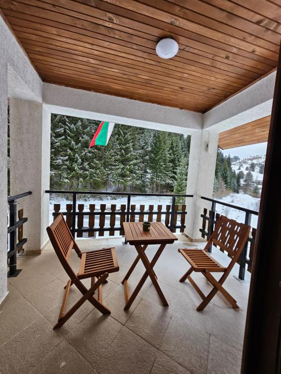 Stoykite的住宿－Планински перли, дом 1，一个带两把椅子和一张桌子的门廊和风筝