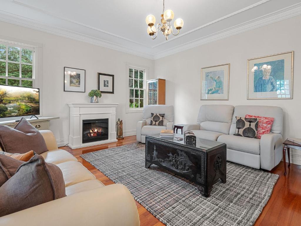 a living room with a couch and a fireplace at The Folly in Bilpin