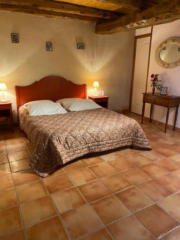 een slaapkamer met een bed en twee tafels en twee lampen bij LA FERME JARLAN in Berganty