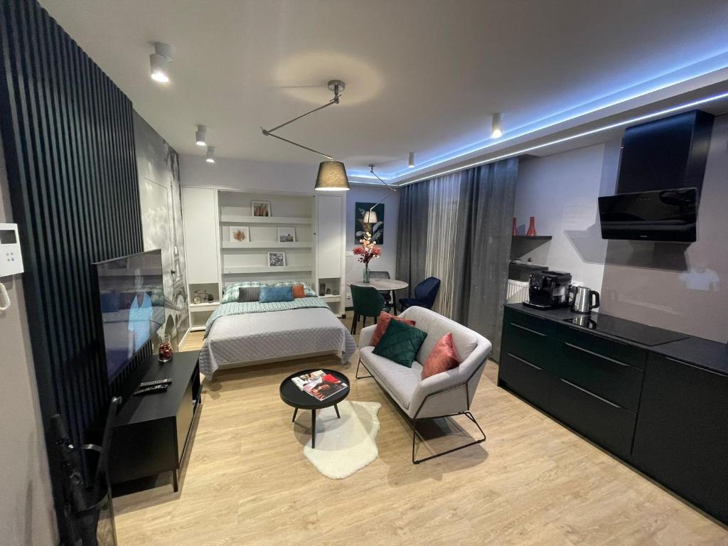 een woonkamer met een bed, een bank en een tafel bij New comfortable apartment with balcony and sauna on Klimieckiego street in Krakau