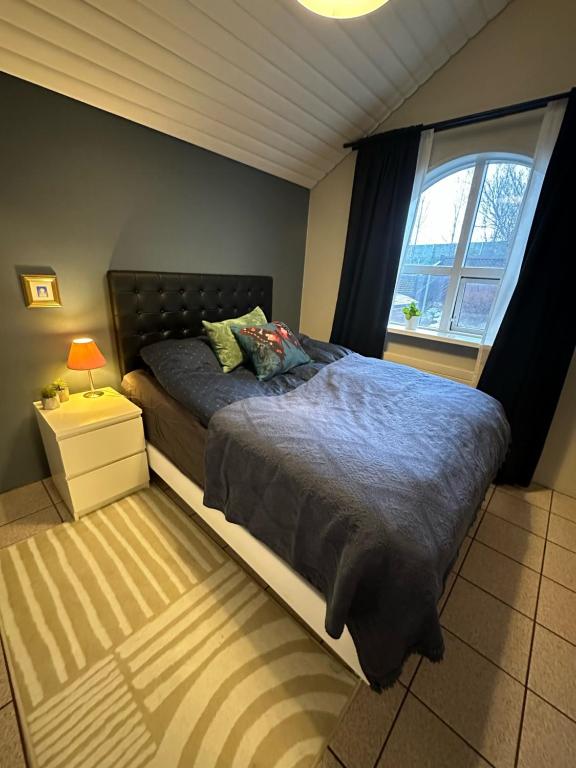 a bedroom with a large bed and a window at Stay Iceland apartments - S 24 in Garðabær