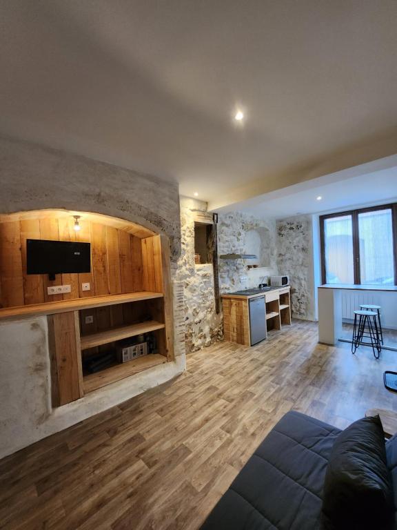 een woonkamer met houten kasten en een keuken bij Le meublé de Jules et Jade in Casteljaloux