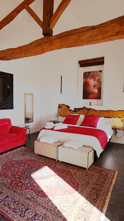 - une chambre avec un grand lit et un canapé rouge dans l'établissement Chambres d'Hôtes Doux Brazil, à Lisle-sur-Tarn