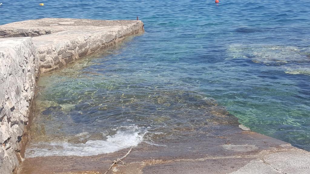 a large body of water next to a stone wall at Heavenly House by the sea in Savudrija