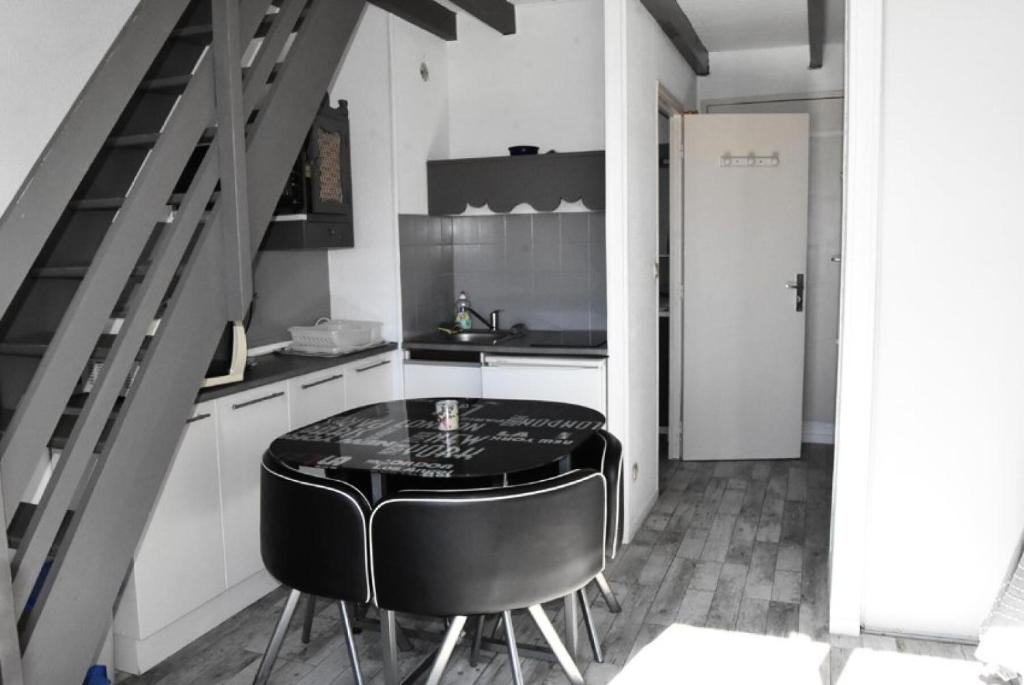 cocina con mesa y taburete negro en Résidence LES PORTES DE LA MEDITERRANEE - Studio pour 4 Personnes 14, en Port Leucate
