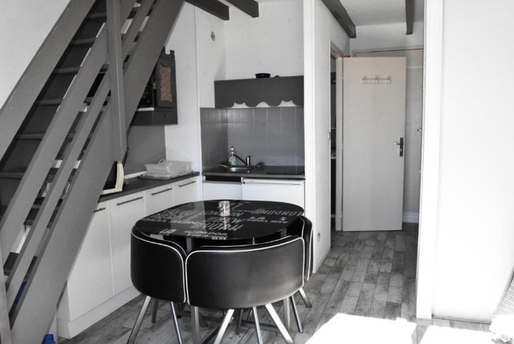 une cuisine avec une table et un tabouret noir dans l'établissement Résidence Les Portes De La Mediterranee - STUDIO 4 PERSONNES 4 couchages PORT LEUCATE MAE-7414, à Port-Leucate