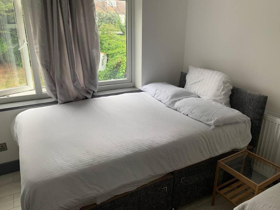 a bed sitting in a room with a window at Modern Brand New Build STUDIO Apartments LONDON in London