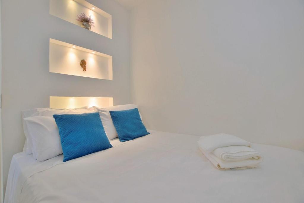 1 cama blanca con almohadas azules en una habitación en O melhor Flat do Lake Side en Brasilia