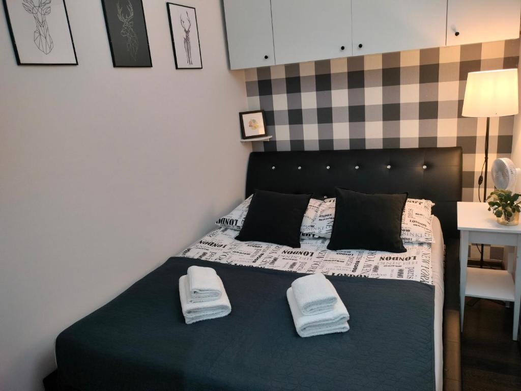 a bedroom with a bed with two towels on it at Apartament Baldachówka in Rzeszów