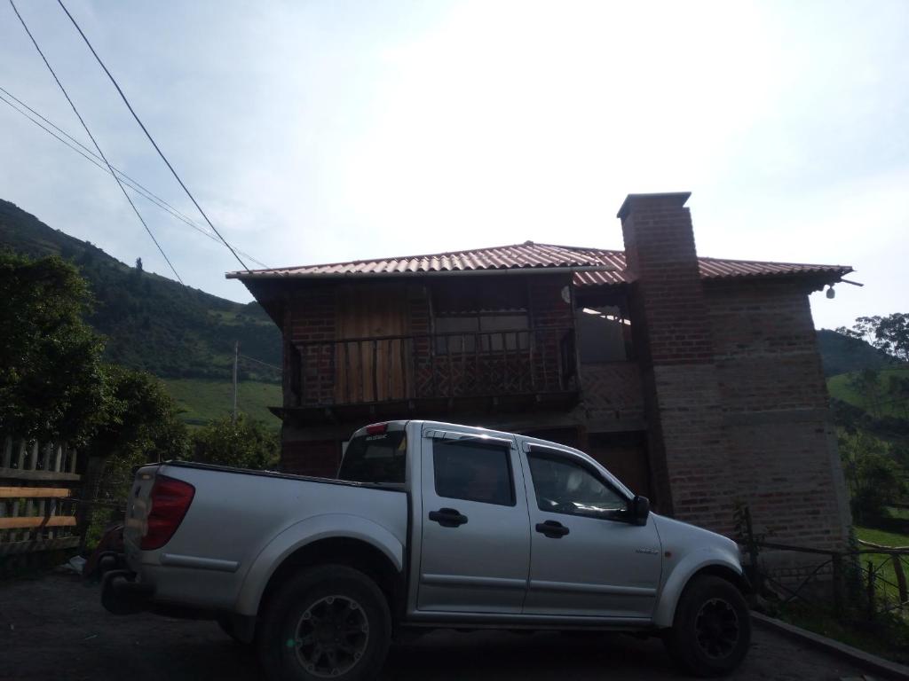 un camión blanco estacionado frente a una casa en Mamá Naty y sus Neguitos, en Chambo