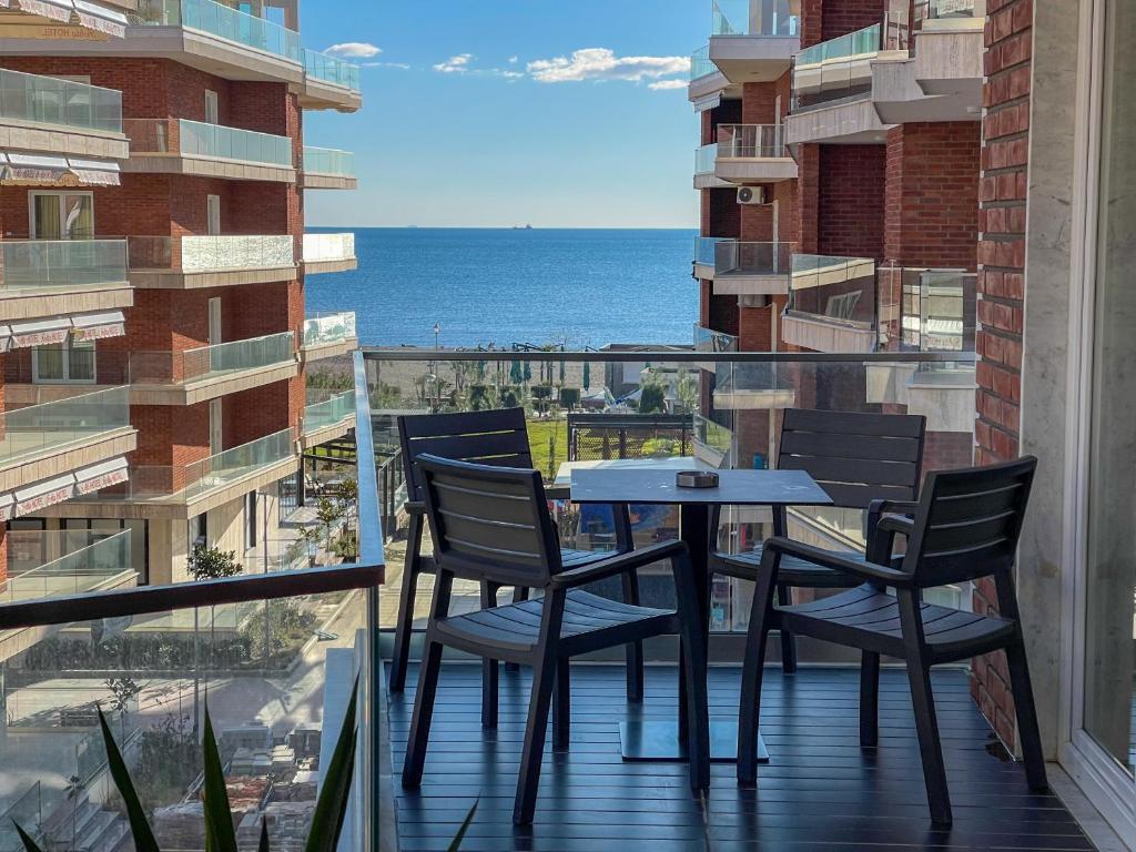 a table and chairs on a balcony with a view of the ocean at Fishta Quality Apartments Q5 36 in Velipojë