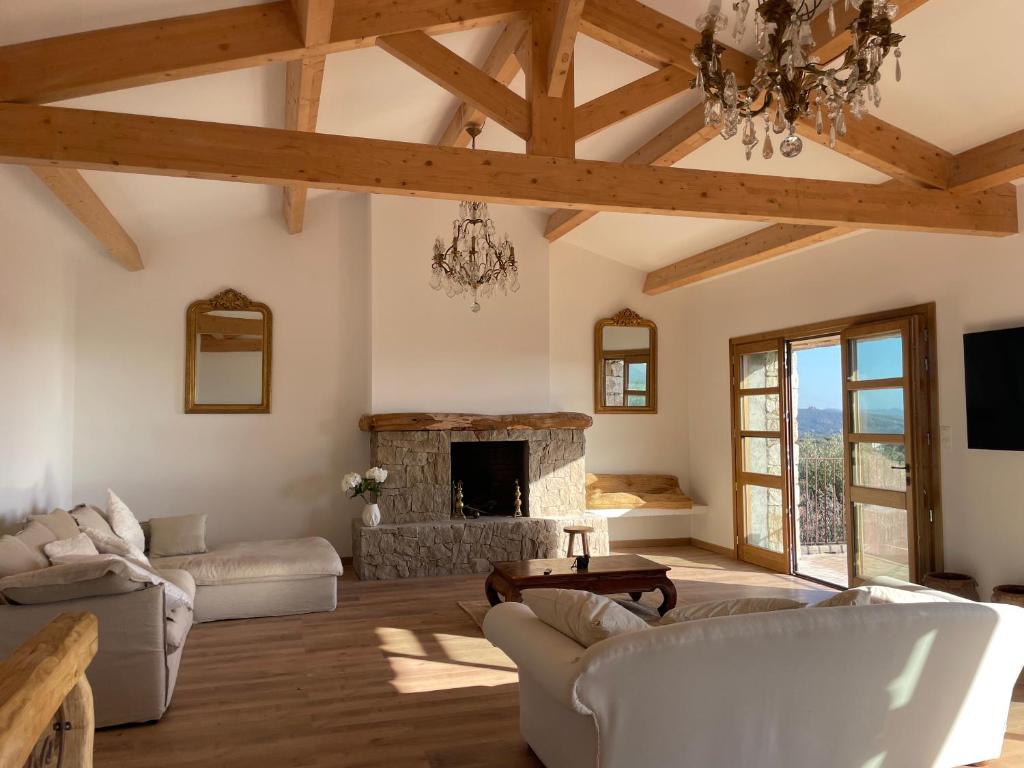 Il comprend un salon doté d'une cheminée en pierre et d'un lustre. dans l'établissement Villa proche plage extrême sud Corse, à Monacia-dʼAullène