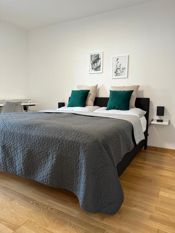 um quarto com uma cama grande e almofadas verdes em Harmony Living - 10 min to Graz em Lassnitzhöhe