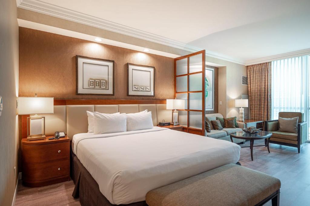 - une chambre avec un grand lit et un salon dans l'établissement No Resort Fee Strip View Suite + Free Valet + Pool, à Las Vegas