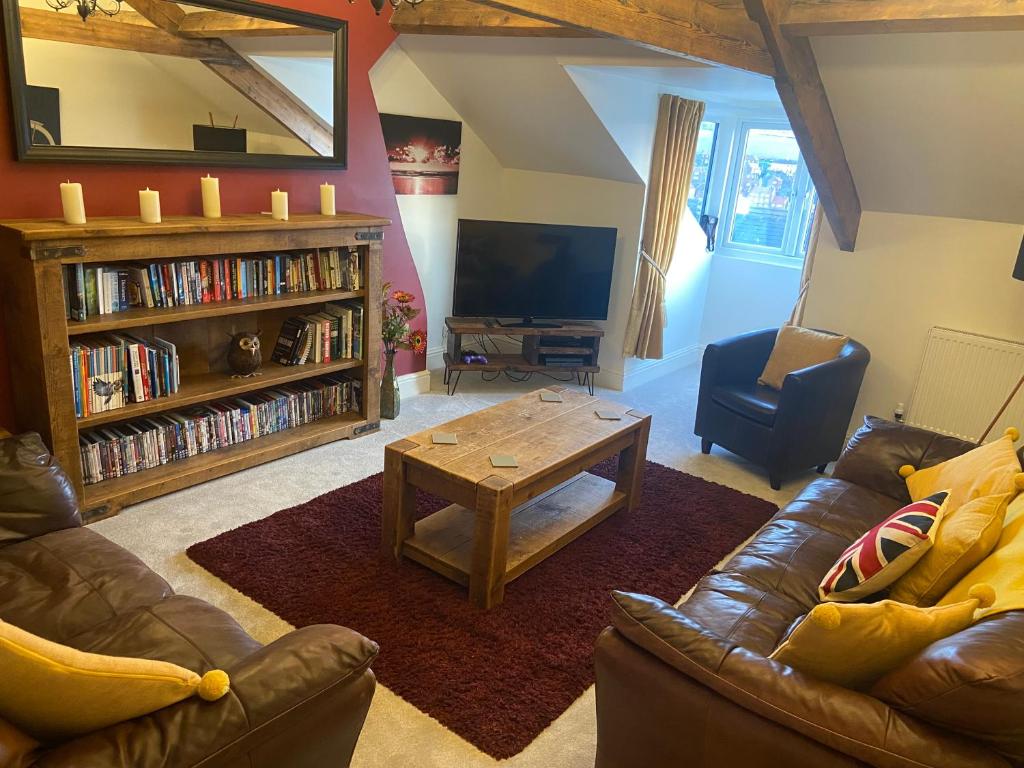 uma sala de estar com um sofá de couro e uma mesa de centro em County Loft Penthouse Apartment em Whitby