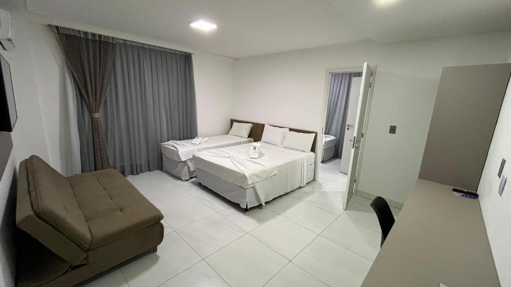 Habitación de hotel con cama y silla en EL SHADDAI HOTEL en João Pessoa