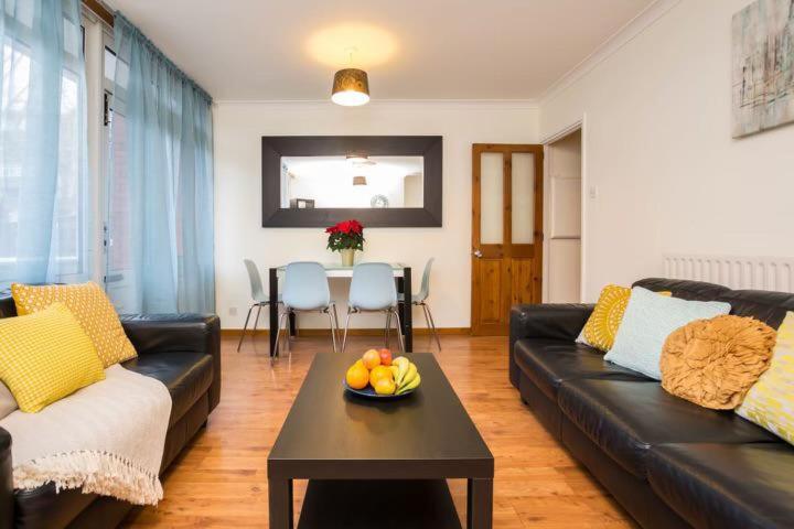 a living room with a couch and a table with a bowl of fruit at 3 Bedroom Flat in Central London in London