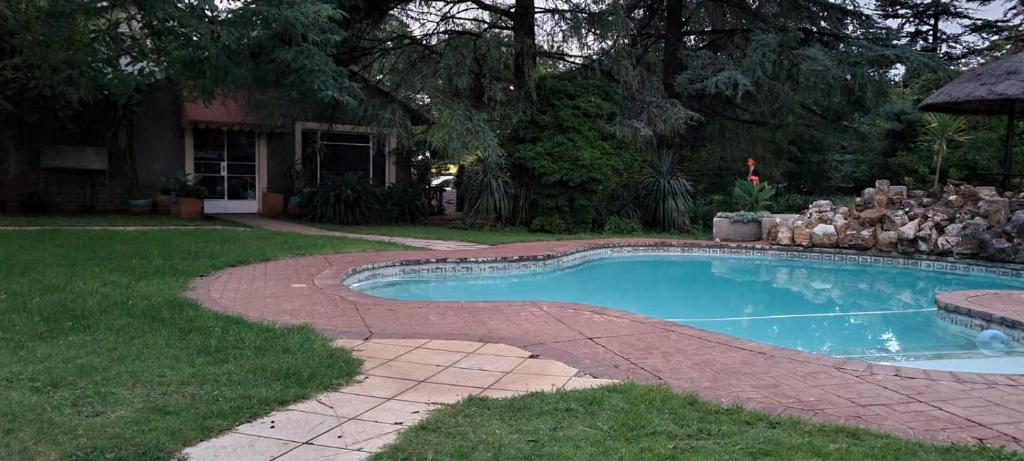a swimming pool in the yard of a house at Silken Trap Guest House NO LOADSHEDDING in Johannesburg