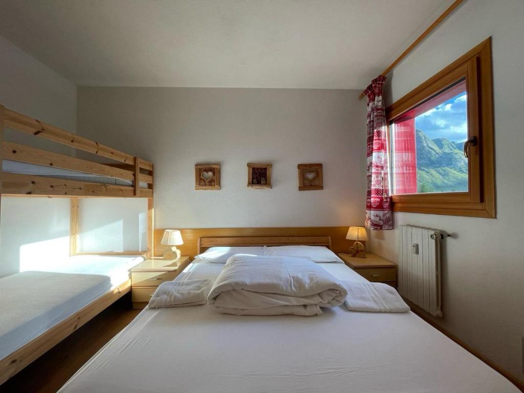 a bedroom with two beds and a window at Casa Pisolo - presso Sussy Residence in Falcade