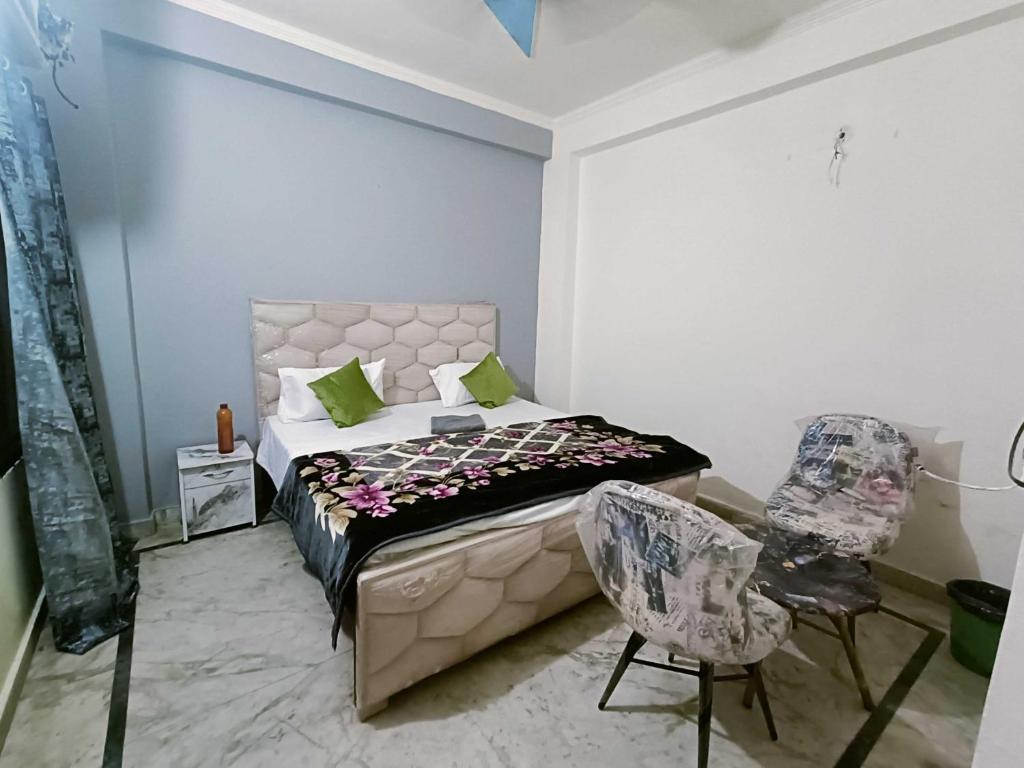 - une chambre avec un lit et deux chaises dans l'établissement Hotel O D 3 residency, à Ghaziabad