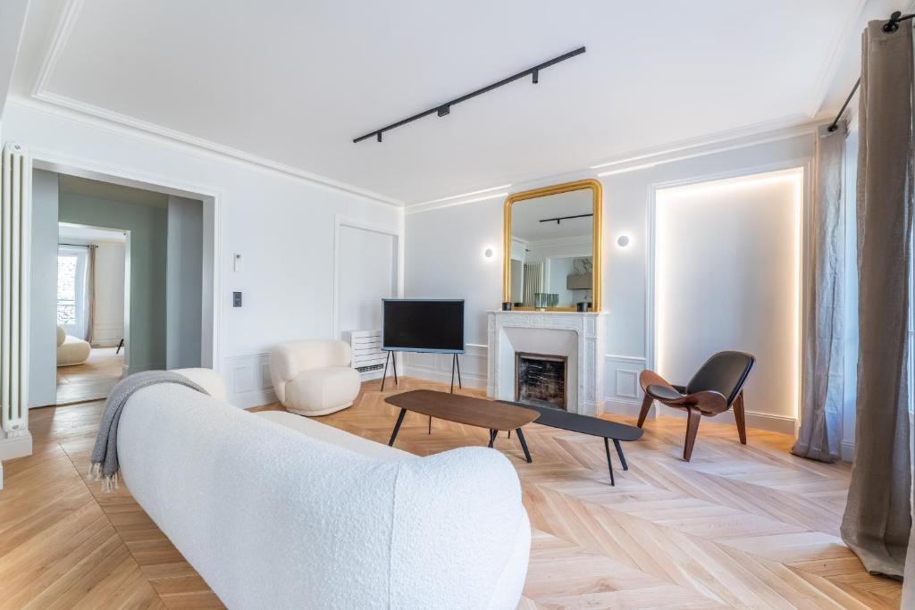 a living room with a white couch and a fireplace at Luxury Living in Trocadéro in Paris