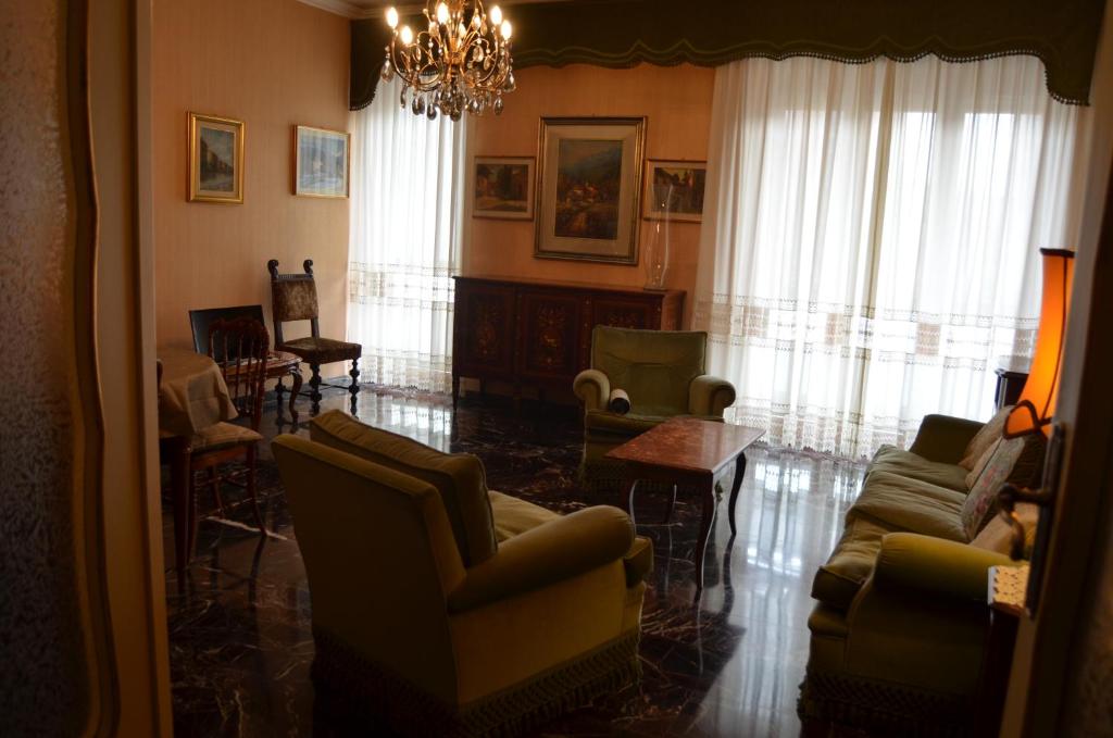uma sala de estar com sofás e cadeiras e um lustre em Eleganza vicino al centro di Torino em Turim