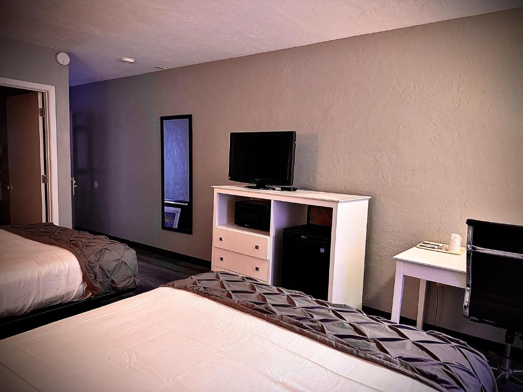 a hotel room with a bed and a tv and a room at Heritage House Inn in Hyannis