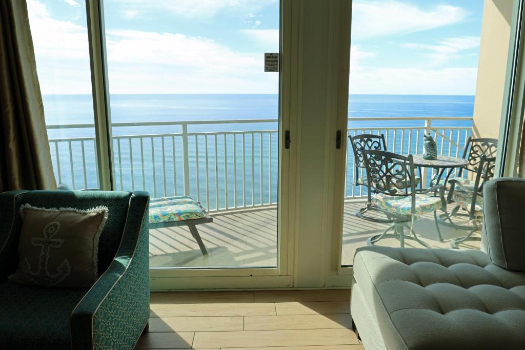 a living room with a view of the ocean from a balcony at AQUA 1504 Beachfront condo with Free Beach Chairs in Panama City Beach