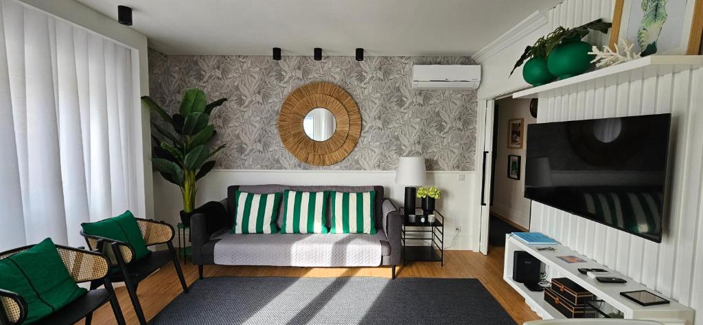 uma sala de estar com um sofá e uma televisão em Casa "Vô Lando" - Nazaré - Alojamento Local na Nazaré