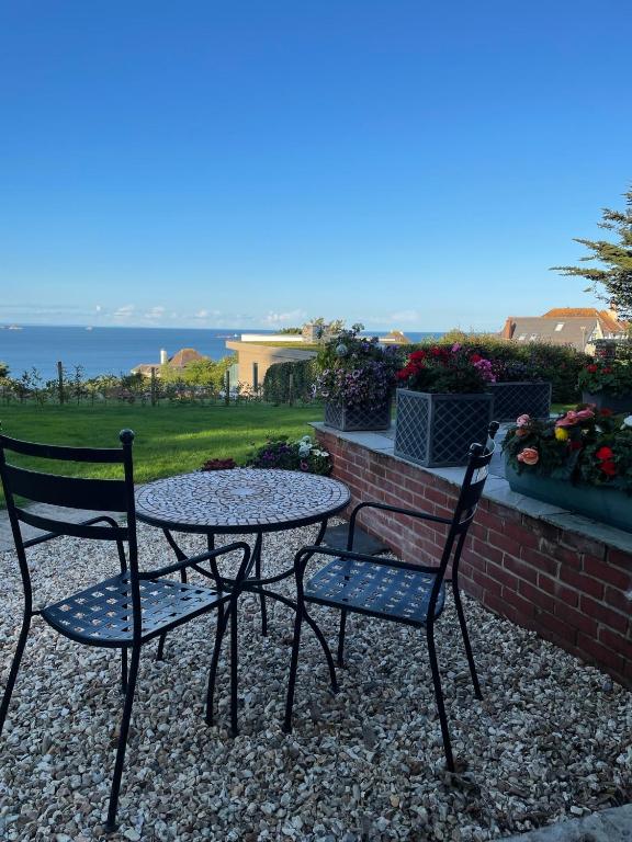 two chairs and a table on a patio with the ocean at The Stoep in Paignton