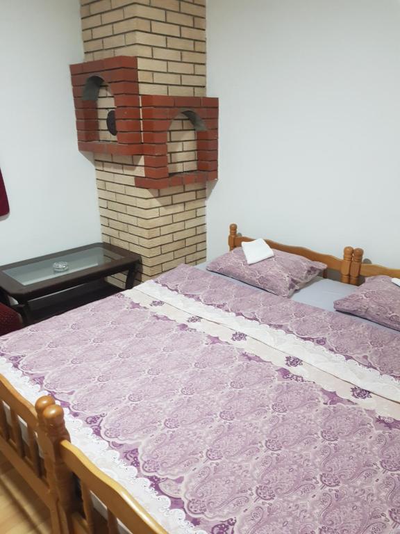 um quarto com uma cama e uma lareira de tijolos em Apartman Break 2 em Bijeljina