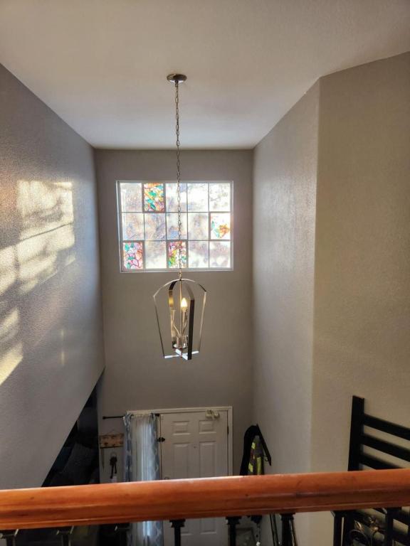 een kamer met een trap met een raam en een kroonluchter bij private bedroom in beautiful large home in Firestone